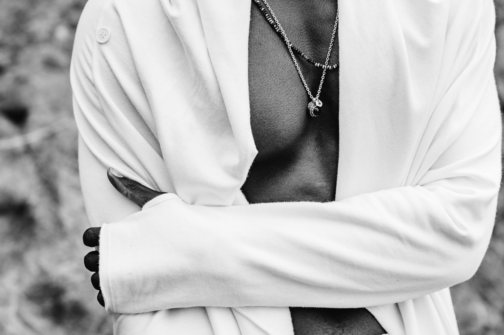 Copala model with arms crossed in an open white shirt and silver chains, black-and-white menswear detail by Chauncey Scott, Malibu CA