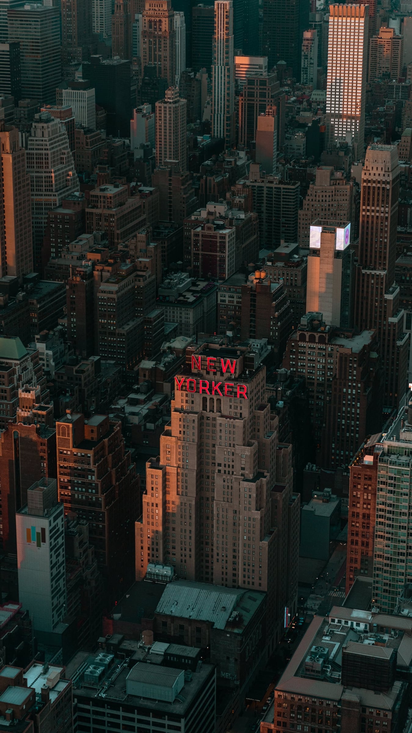 Aerial view of Midtown Manhattan at dusk with The New Yorker Hotel neon sign, New York City — editorial photography by Chauncey Scott, commercial photographer