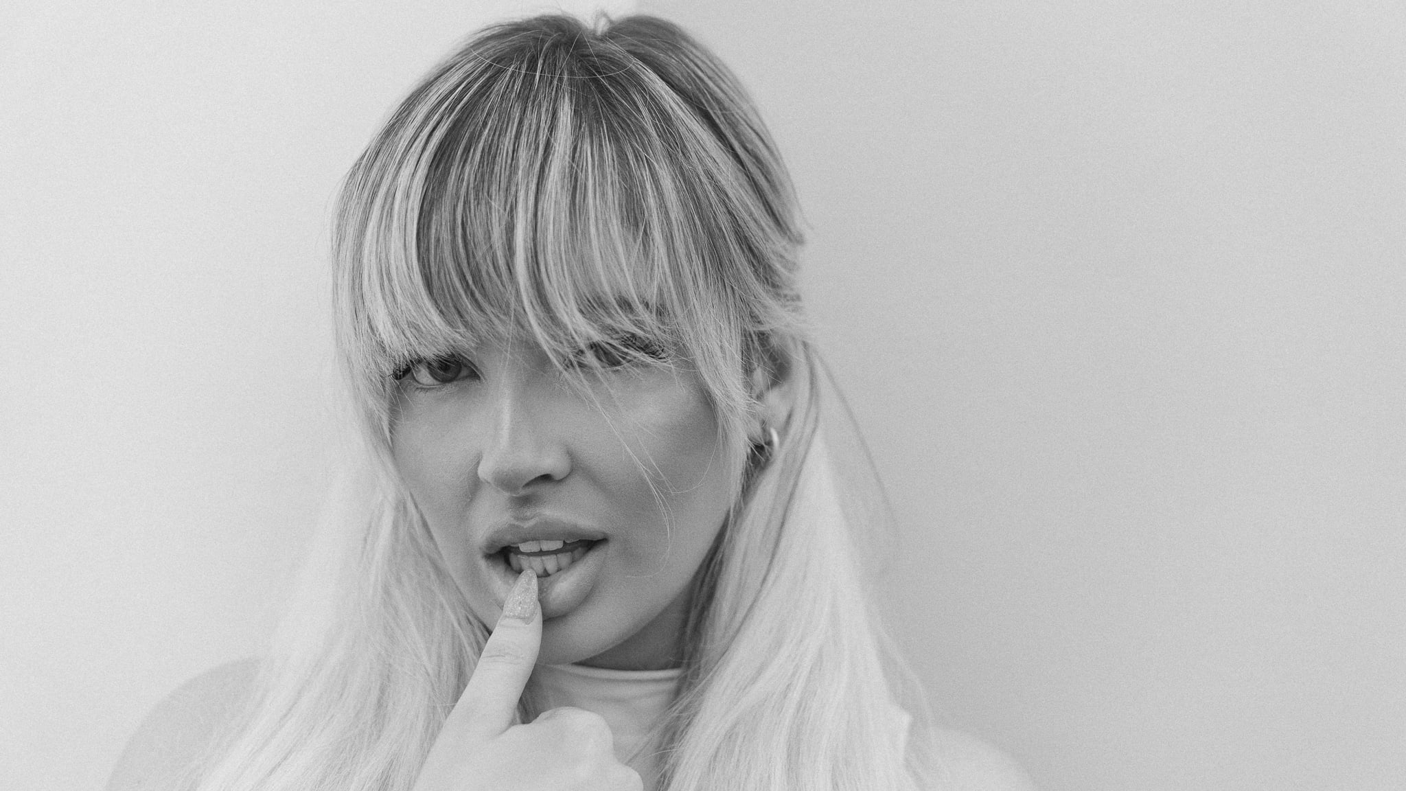 Playboy Austin portrait in black and white — blonde model with bangs, finger to her lips, editorial beauty photography by Chauncey Scott, Austin TX