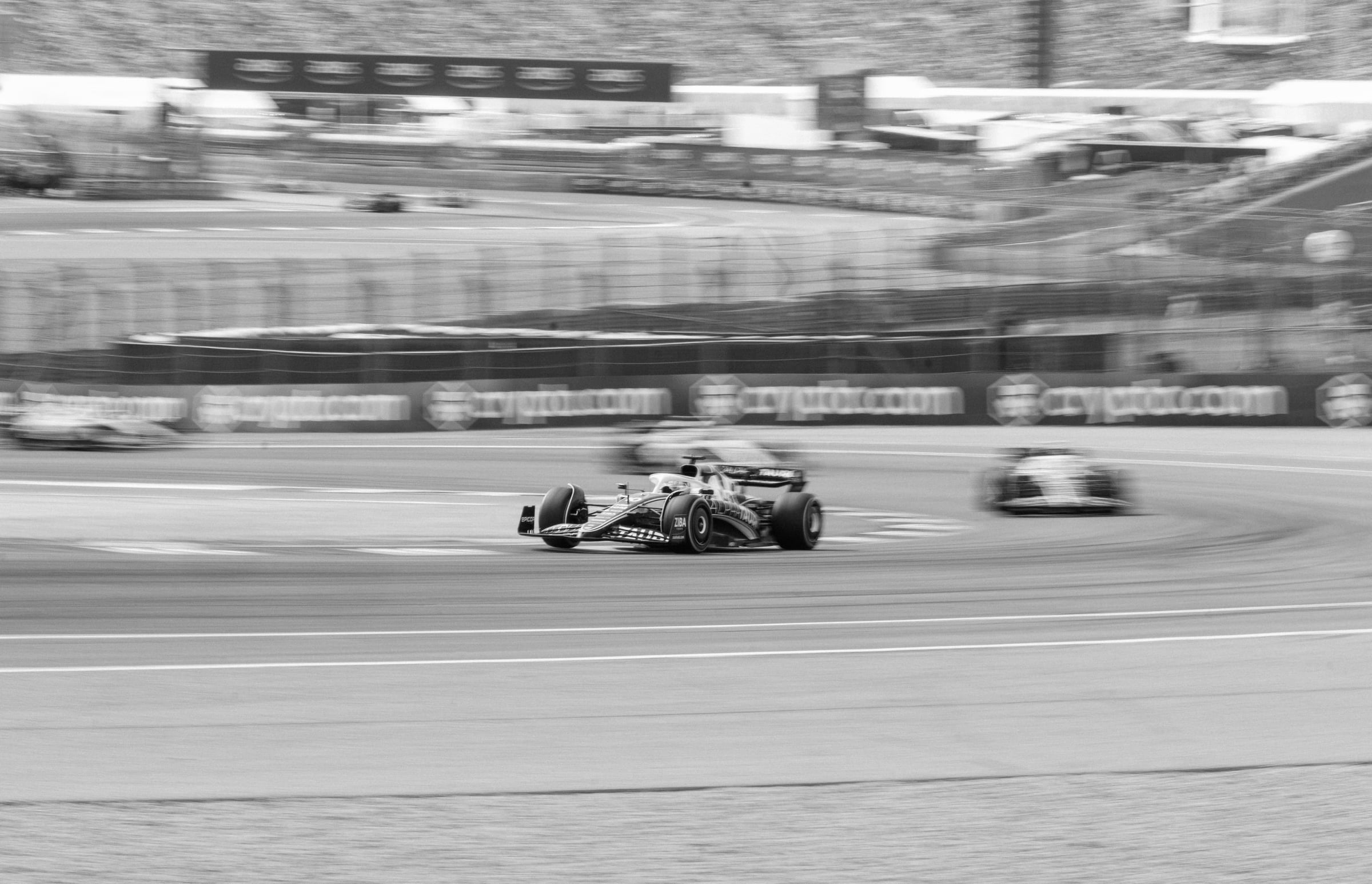 Scuderia AlphaTauri AT03 panning through Circuit of the Americas with multiple F1 cars in motion, F1 United States Grand Prix Austin TX 2022 — press-credentialed motorsports photographer Chauncey Scott